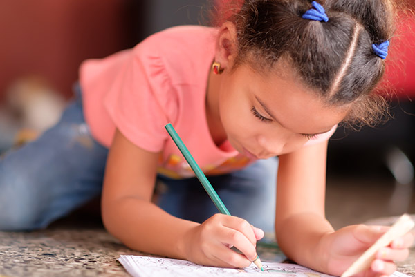 criança fazendo tarefa no caderno